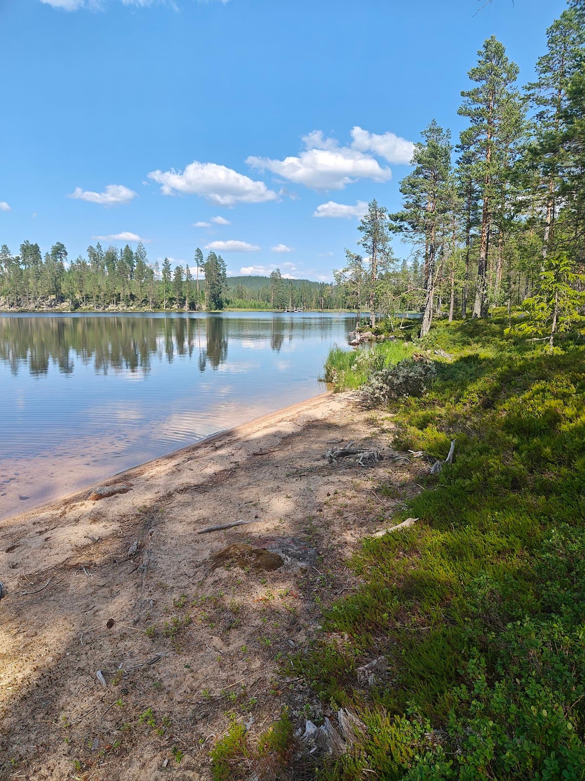 Rastplats Sandsjön vid sjön längs E4 i Småland med utsikt över vattnet och en lekplats.
