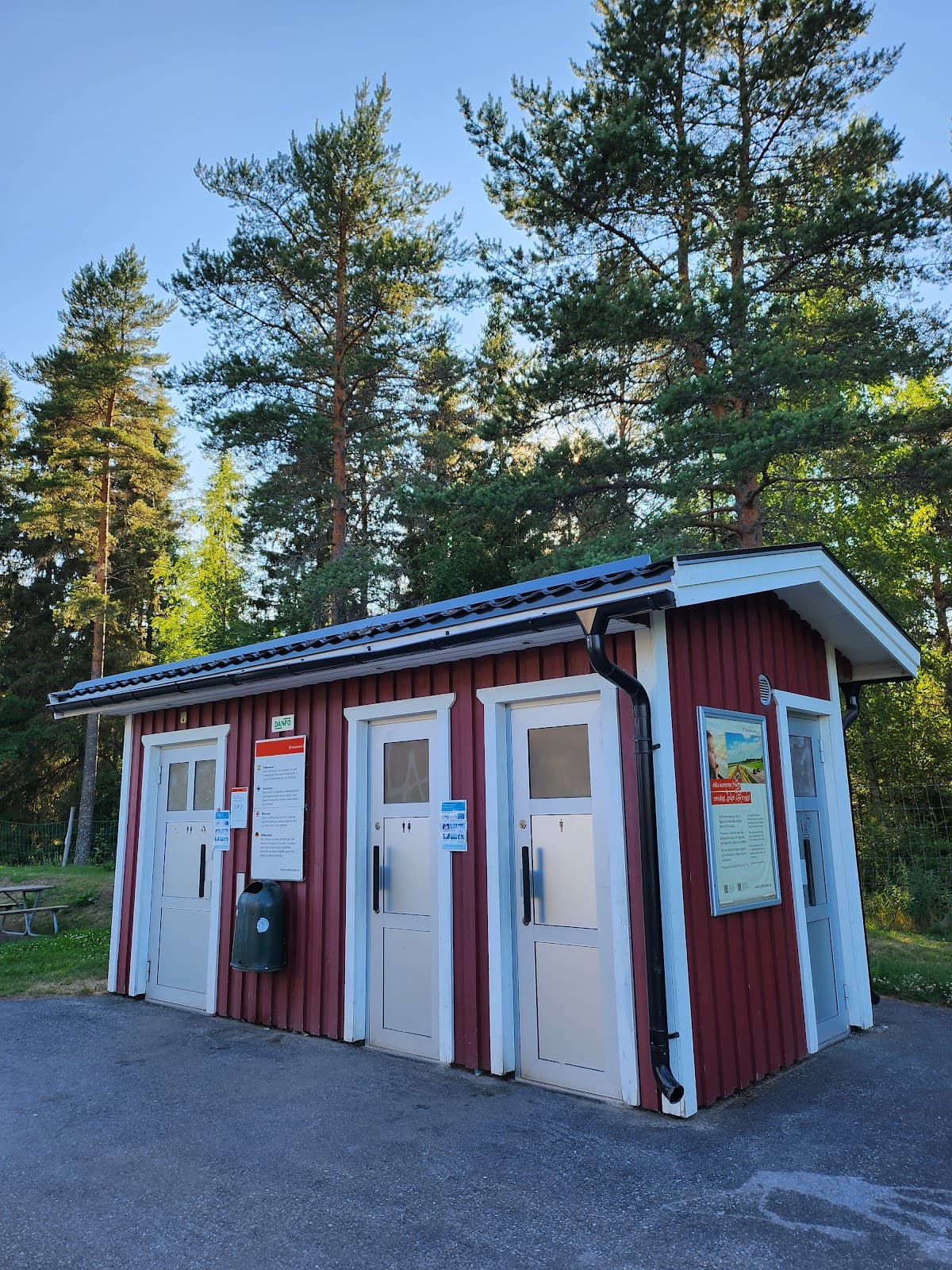 Rastplats Åhedån N vid E4 i Västerbotten omgiven av grönskande barrskog.
