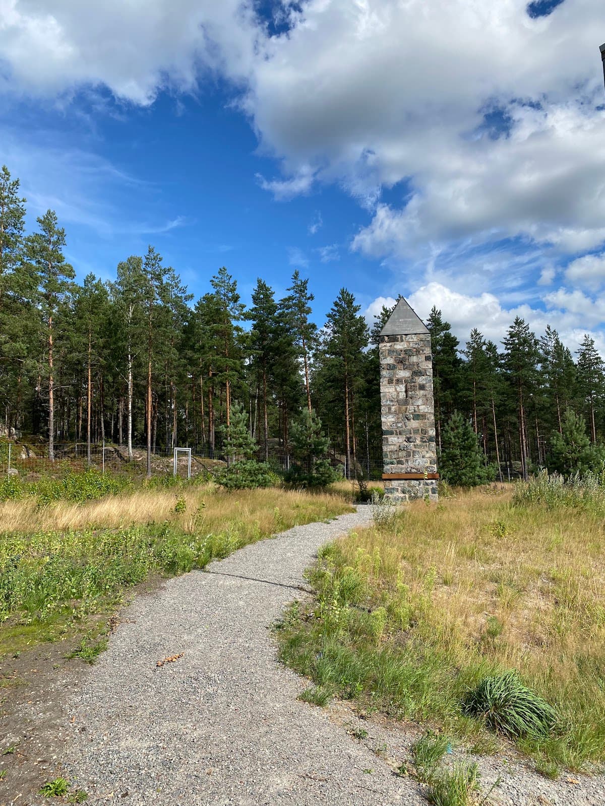 Vy över rastplats Bergslagsporten vid E18 nära Karlskoga med sittplatser och omgivande skog.