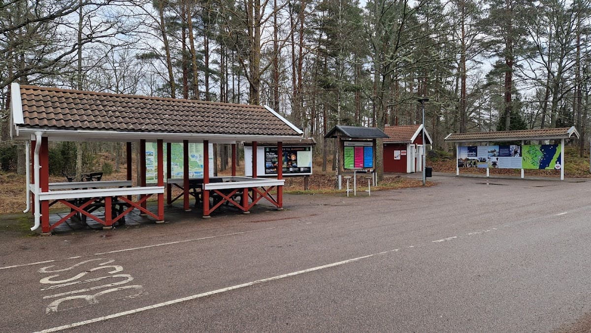 Naturskön vy över rastplats Emån V med sittplatser intill den lugna Emån i Småland.