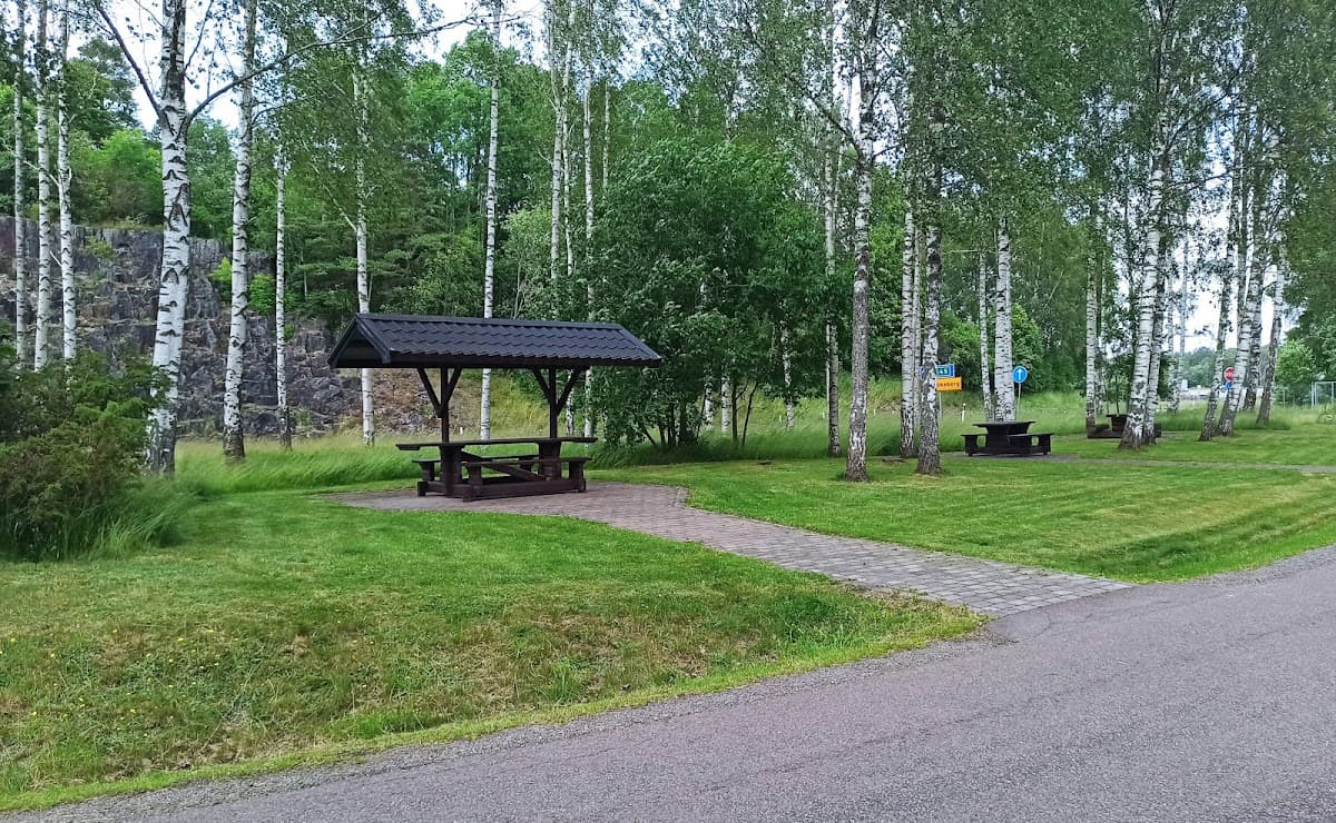 Linderud rastplats vid E18 i Värmland, omgiven av lummig skog och sittplatser.