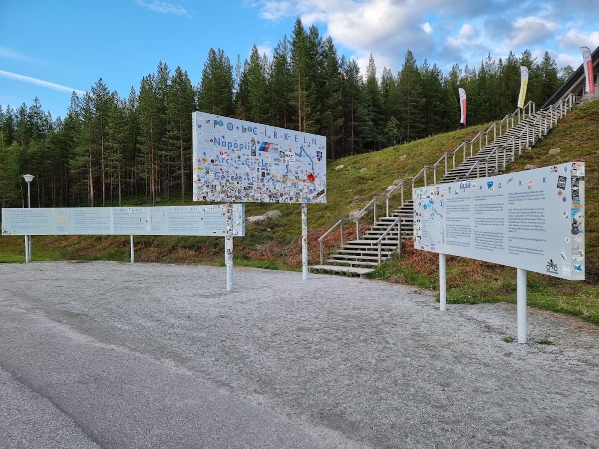 Rastplats vid Polcirkeln längs E45 norr om Jokkmokk, omgiven av lappländsk skog.