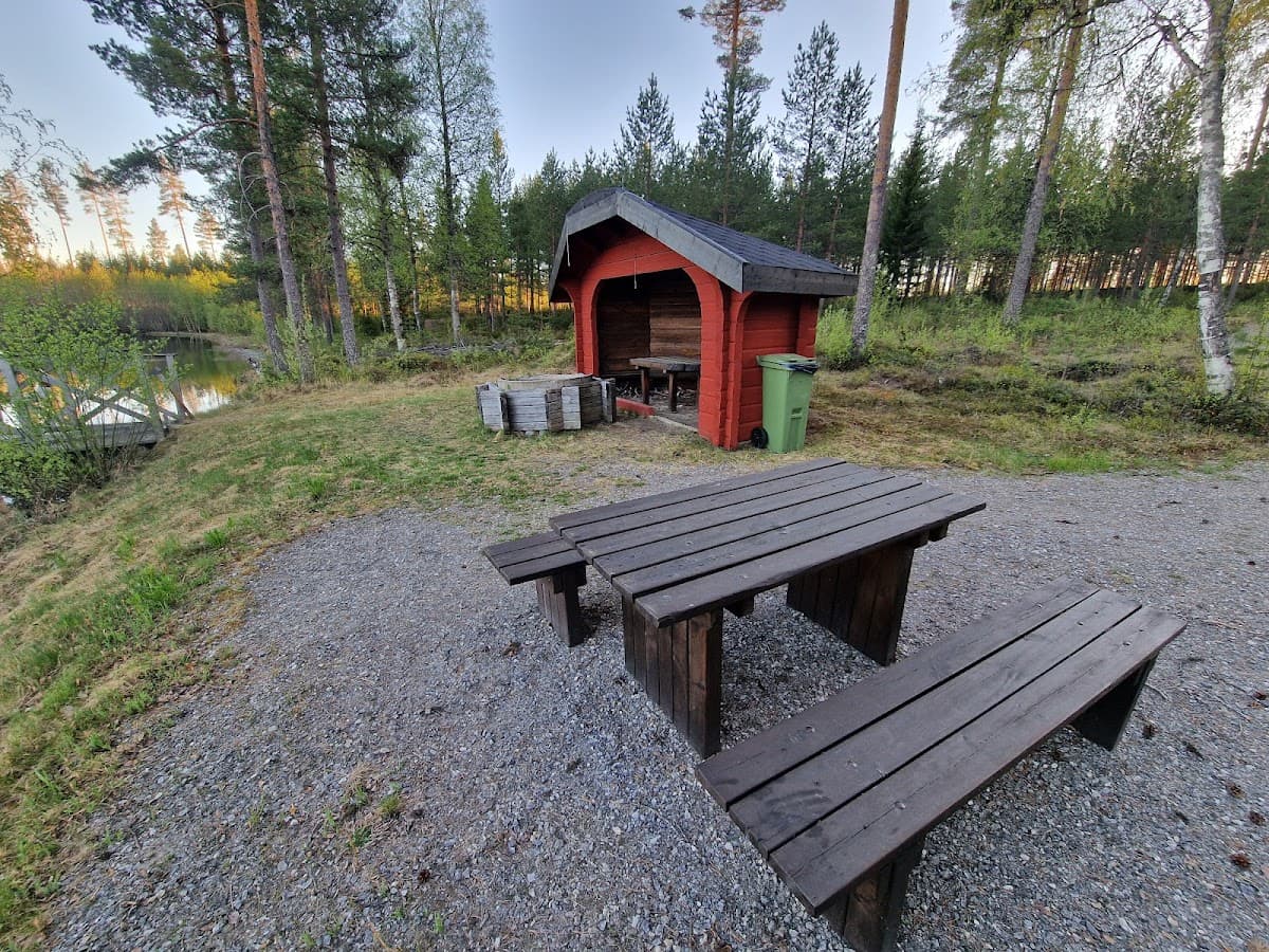 Rastplats Tallbacken vid E4 med höga tallar, sittplatser och lekplats i grönskande småländsk natur.